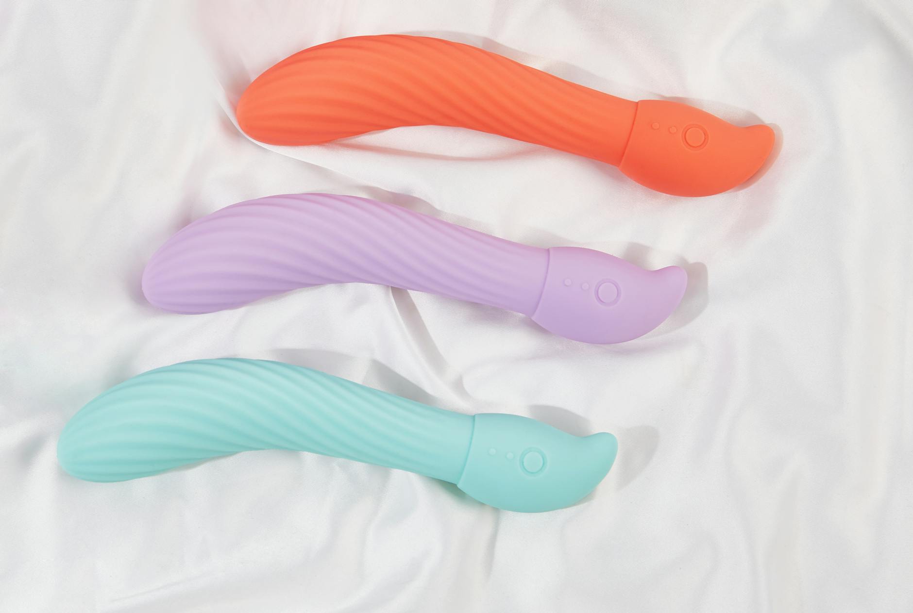 Three colorful lemon vibrators arranged on white fabric, highlighting their smooth texture and design variations.