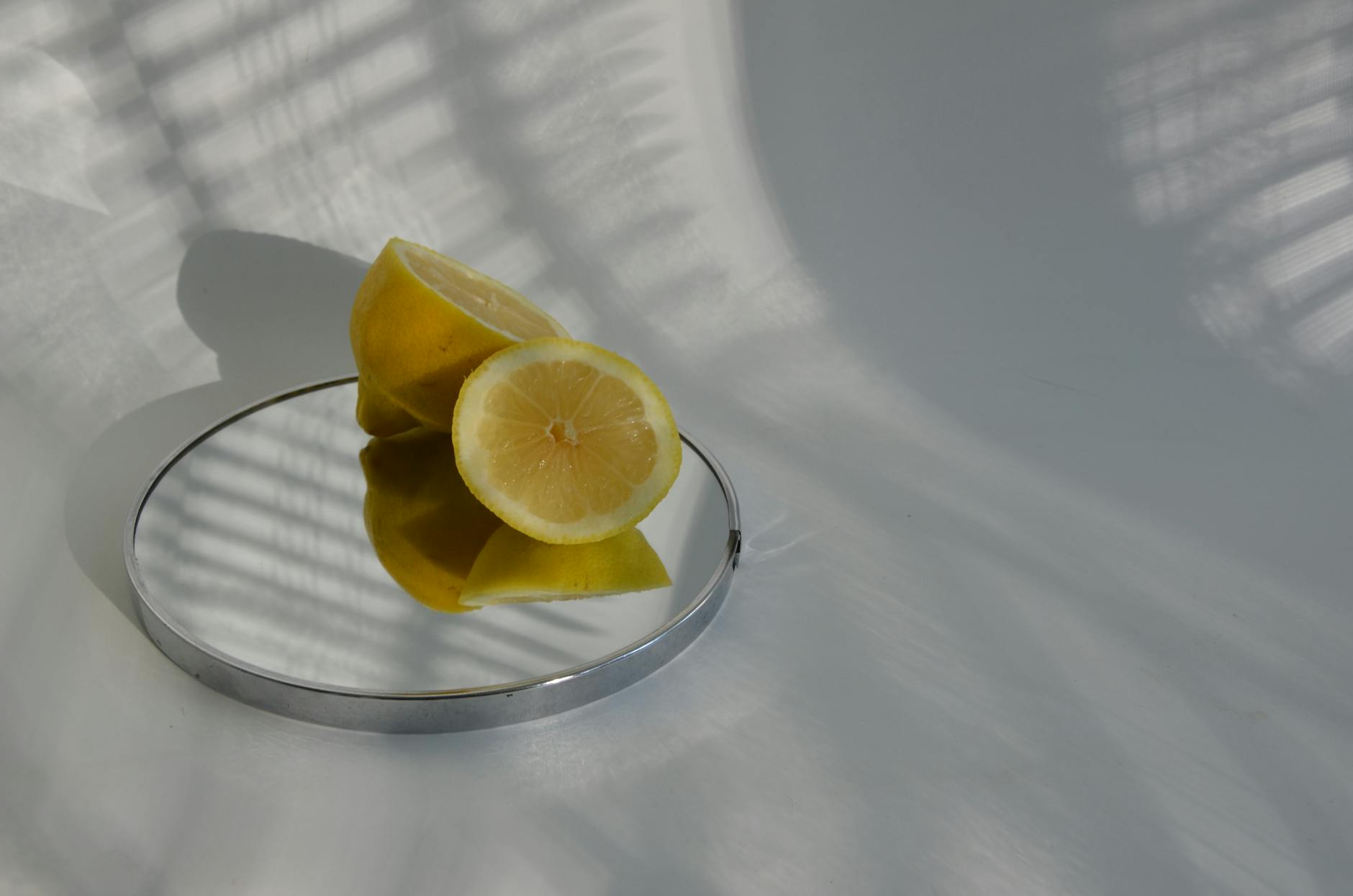 Hand holding a fresh lemon against a vivid yellow background, symbolizing renewal and restored sensitivity.